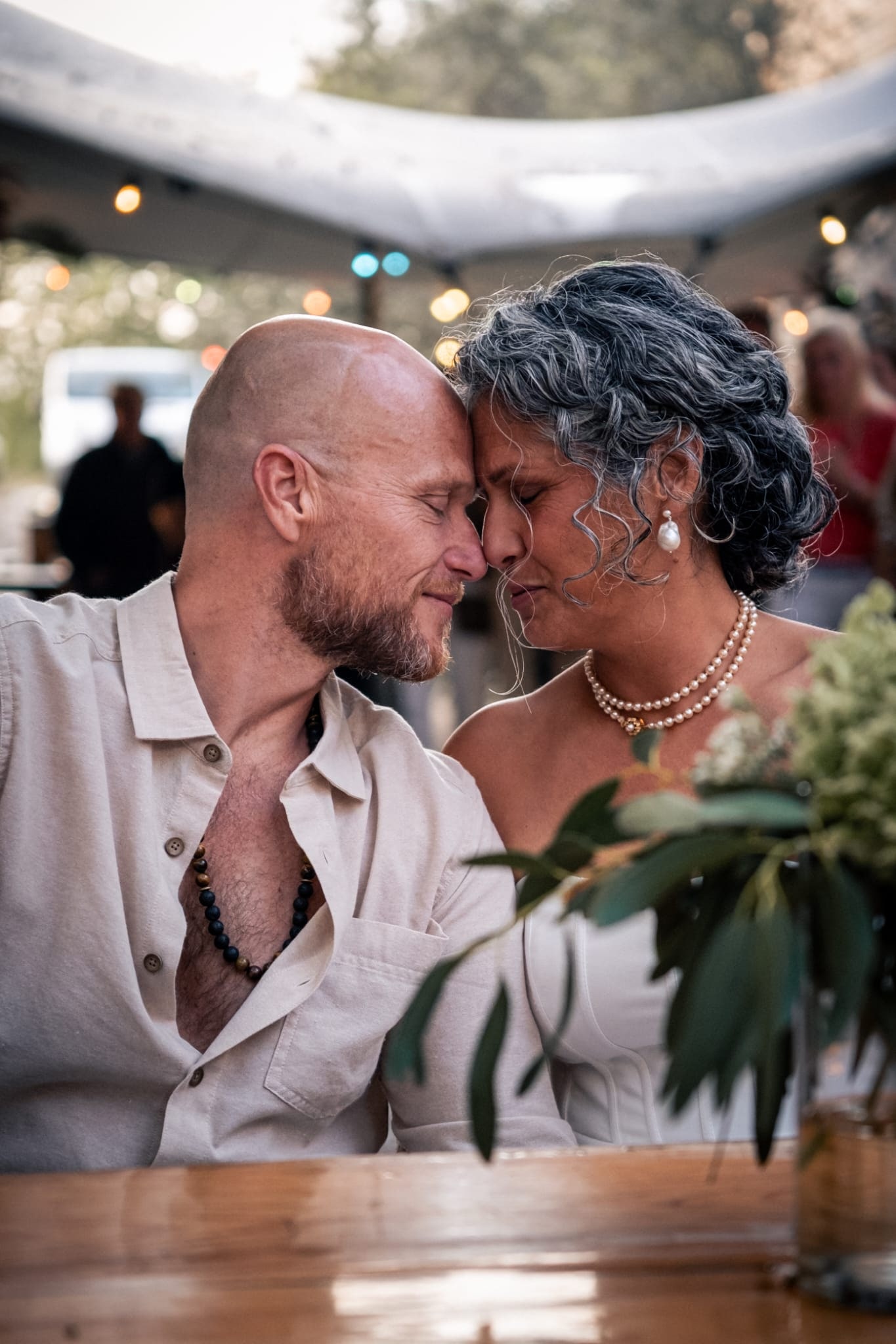 Danielle en Mark raken met gesloten ogen hun voorhoofden tegen elkaar aan op hun trouwdag.